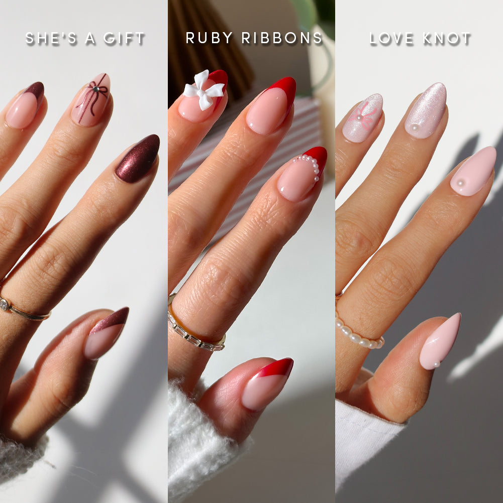 Three hands showcase Valentine-themed press-on nails from glamnetic’s Fifth Ave Gift Display: burgundy with a bow, pink with a white ribbon and pearls, and shimmery pink with a knot and stud. Each hand is labeled with the design’s name, highlighting salon-quality manicures that make it easy to create your own holiday nail bundle. - Product image