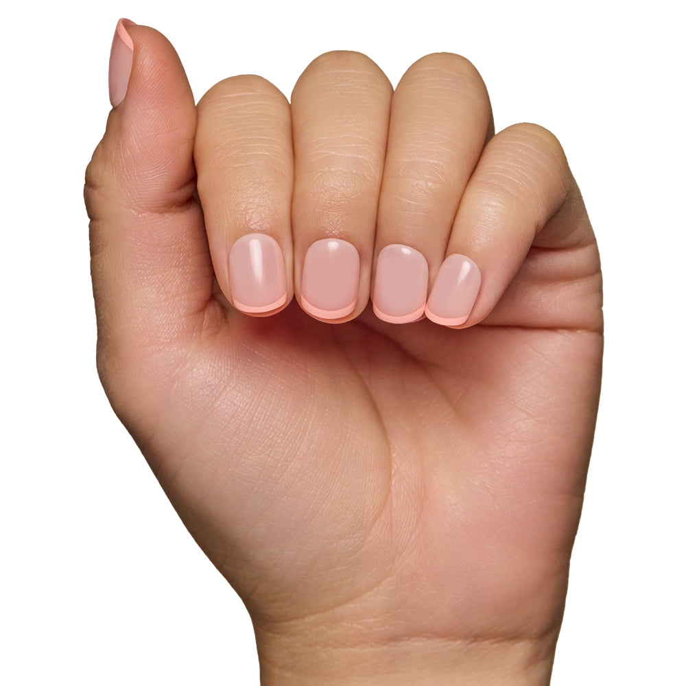 A hand with neatly manicured, light pink French Peach nails by glamnetic, which are vegan and cruelty-free, is shown against a white background. The slightly bent fingers highlight the elegant appearance. - Product image