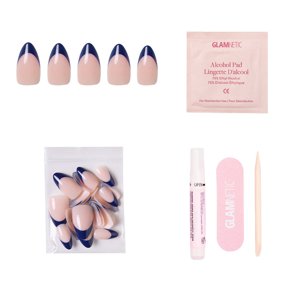 The French Riviera by glamnetic includes navy French tip short almond nails, extra nails, an alcohol pad, nail glue, a pink nail file, and a wooden cuticle stick—all set against a white background. - Product image