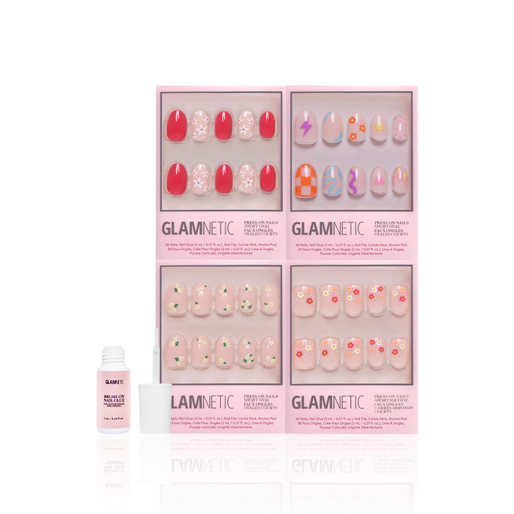 Four boxes of glamnetic Fresh Florals press-on nails, featuring colorful geometric, abstract, and floral designs, are shown above an open nail glue bottle on a white background. - Product image
