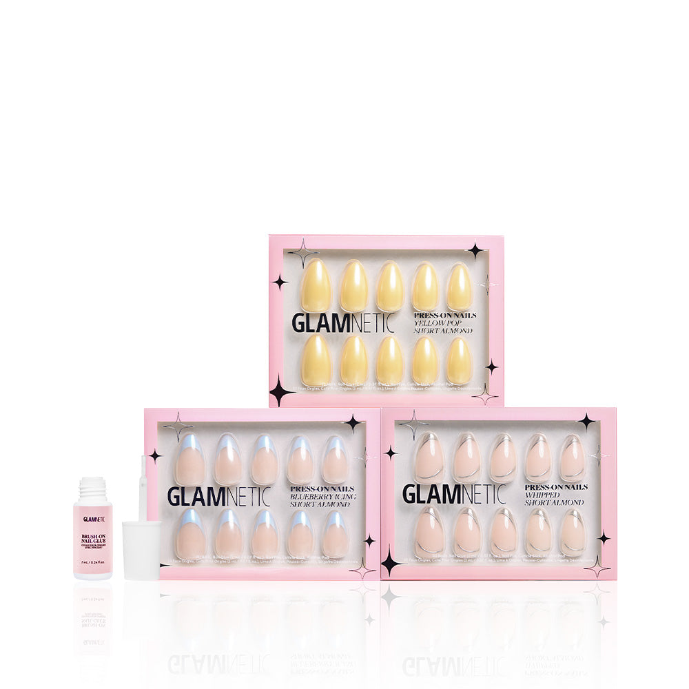 Three boxes of glamnetic Freshly Frosted vegan & cruelty-free press-on nails and a pink bottle of nail glue with a white cap are displayed on a white background. - Product image