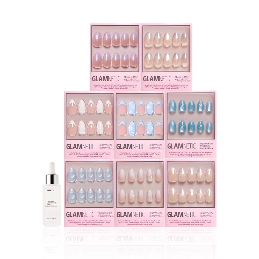 Nine boxes of glamnetic Frozen Over press-on nails in short almond shapes with nude and pastel blue styles, plus a bottle of glamnetic cuticle oil in front—perfect for a chic winter nail set on a white background. - Product image