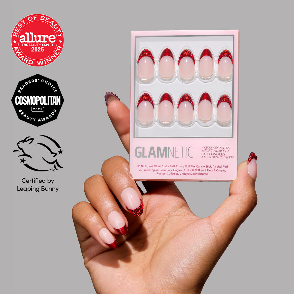 A hand holds a box of glamnetic Garnet press-on nails in bold red and nude. The image displays logos for Allure Best of Beauty 2025, Cosmopolitan Readers Choice 2023, and Leaping Bunny Certified.