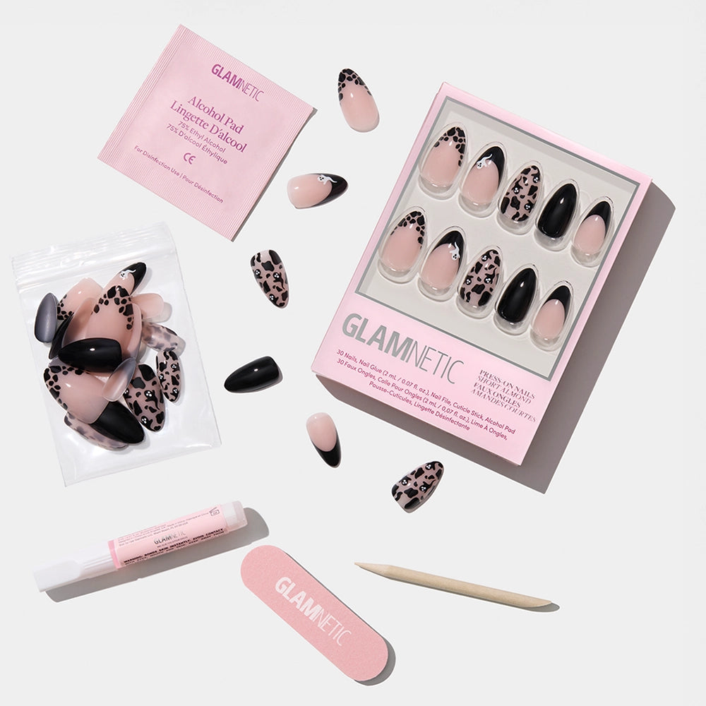 The glamnetic Ghosted set features short almond press-on nails in nude, black, and leopard print, displayed with nail file, cuticle stick, nail glue, cleansing pad, and resealable bag on a white background. - Product image