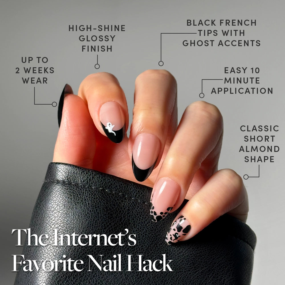 A hand with long, almond-shaped Ghosted by glamnetic black French tip press-on nails and nude nail art holds a black leather item. Durable, salon-finish, viral design—“The Internet’s Favorite Nail Hack.”. - Product image