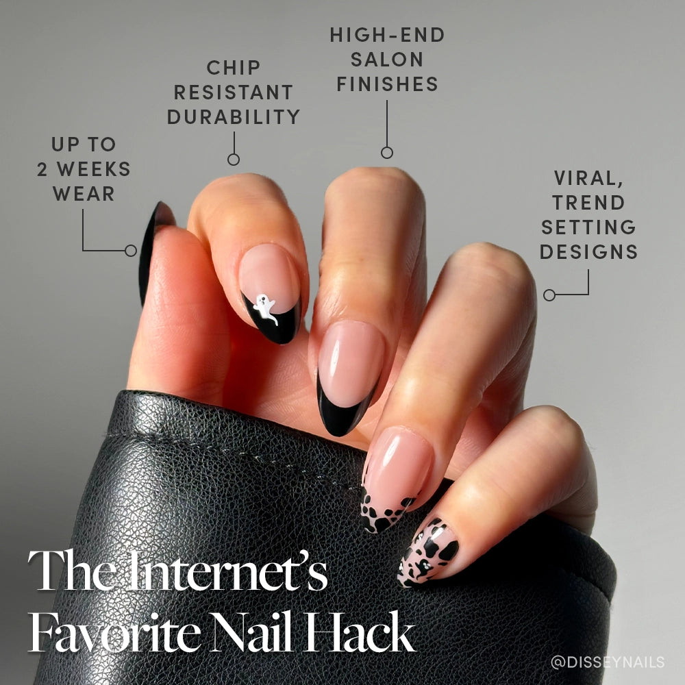 A hand with long, almond-shaped Ghosted by glamnetic black French tip press-on nails and nude nail art holds a black leather item. Durable, salon-finish, viral design—“The Internet’s Favorite Nail Hack.”. - Product image