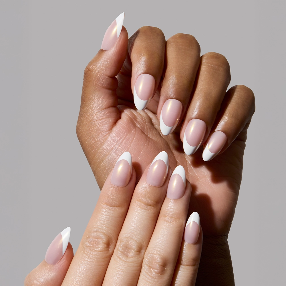 Two hands—one light-skinned and one dark-skinned—wearing the “Give ‘Em Grace” press-on nails, emphasizing how the high-shine champagne pearl finish and white tips suit diverse skin tones with a clean, classic effect.
- Product image