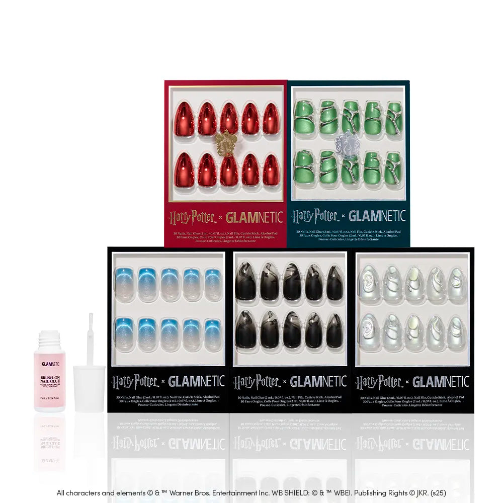 Six boxed sets of Glamnetic House Faves press-on wizarding world nails by glamnetic are displayed on a white background, with a pink glue bottle and applicator. Sets include themed colors, some with metallic chrome nails and 3D accents. - Product image