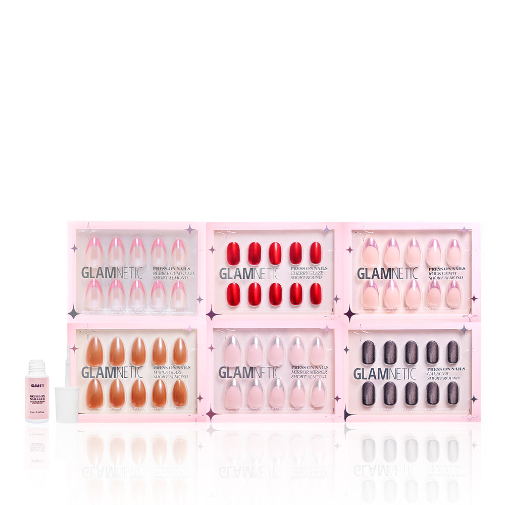 Six sets of glamnetic’s Glossy Collection press-on nails, featuring various colors and shapes including almond style, are shown in pink packaging with a nail glue bottle on the left, all arranged against a white background. - Product image