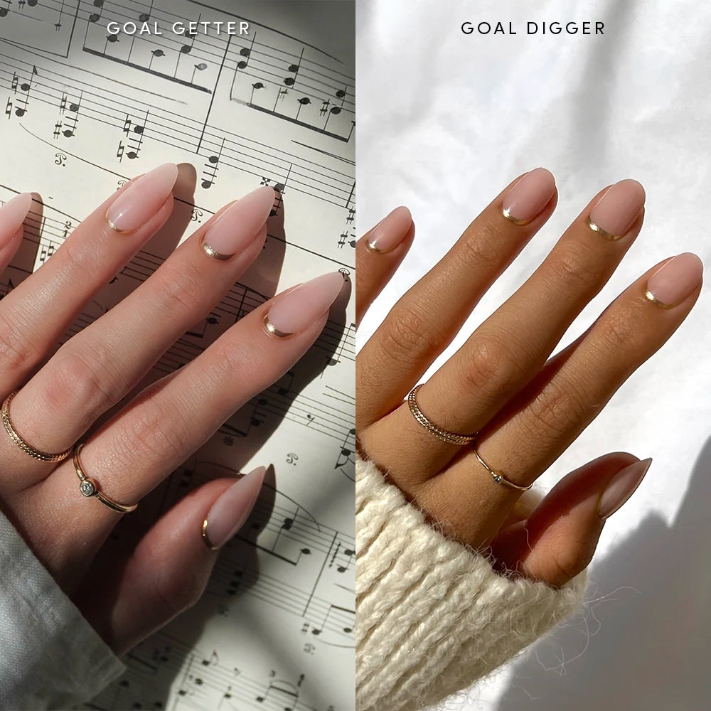 Two hands with manicured nails; the left hand features glamnetic’s Goal Getter: long, almond-shaped sheer nude nails over sheet music. The right hand shows Goal Digger: shorter nails with a chic reverse French tip design. Both sets are accessorized with gold rings and minimalist nail art for a natural look. - Product image