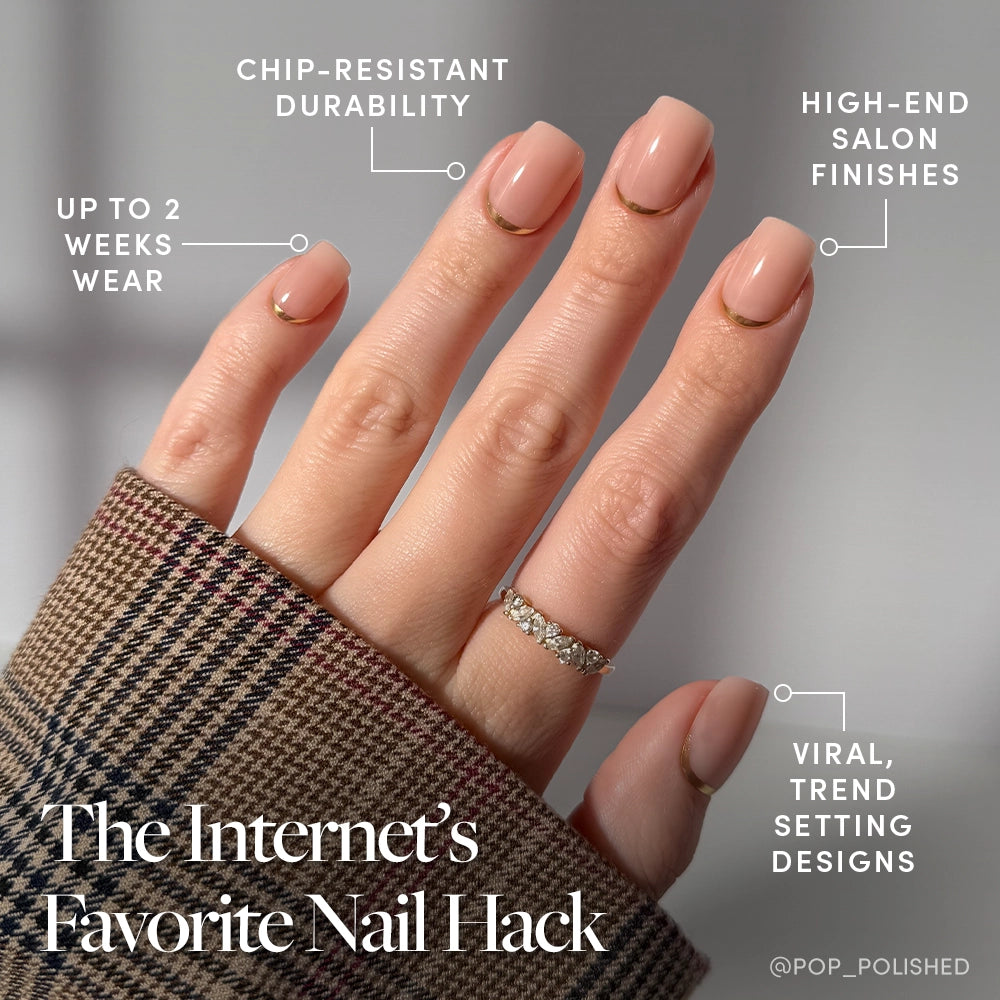 A hand with glossy short squoval nails in glamnetic's Goal Setter, gold half-moon accents, and a sparkly ring is shown. Features: chip-resistant, high-end finish, viral design, up to 2 weeks’ wear. The person wears a plaid sleeve. - Product image