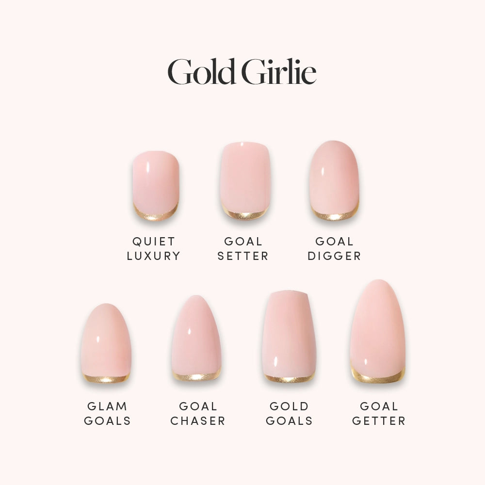 The Gold Girlie Bundle by glamnetic features seven pale pink press-on nails with gold tips, displaying styles like Quiet Luxury and Goal Getter. Each trendy nude French tip nail is labeled with its style name under the bold "Gold Girlie" text. - Product image