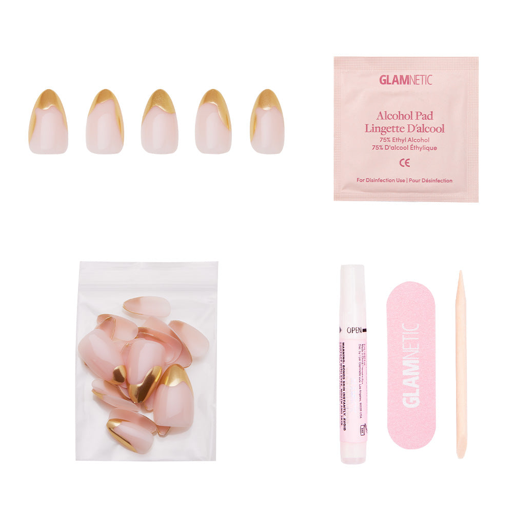 The glamnetic Golden Touch set includes short almond nails with pink and abstract gold foil French tips, plus an alcohol pad, file, cuticle stick, glue pen, and extra nails in a clear bag on a white background. - Product image