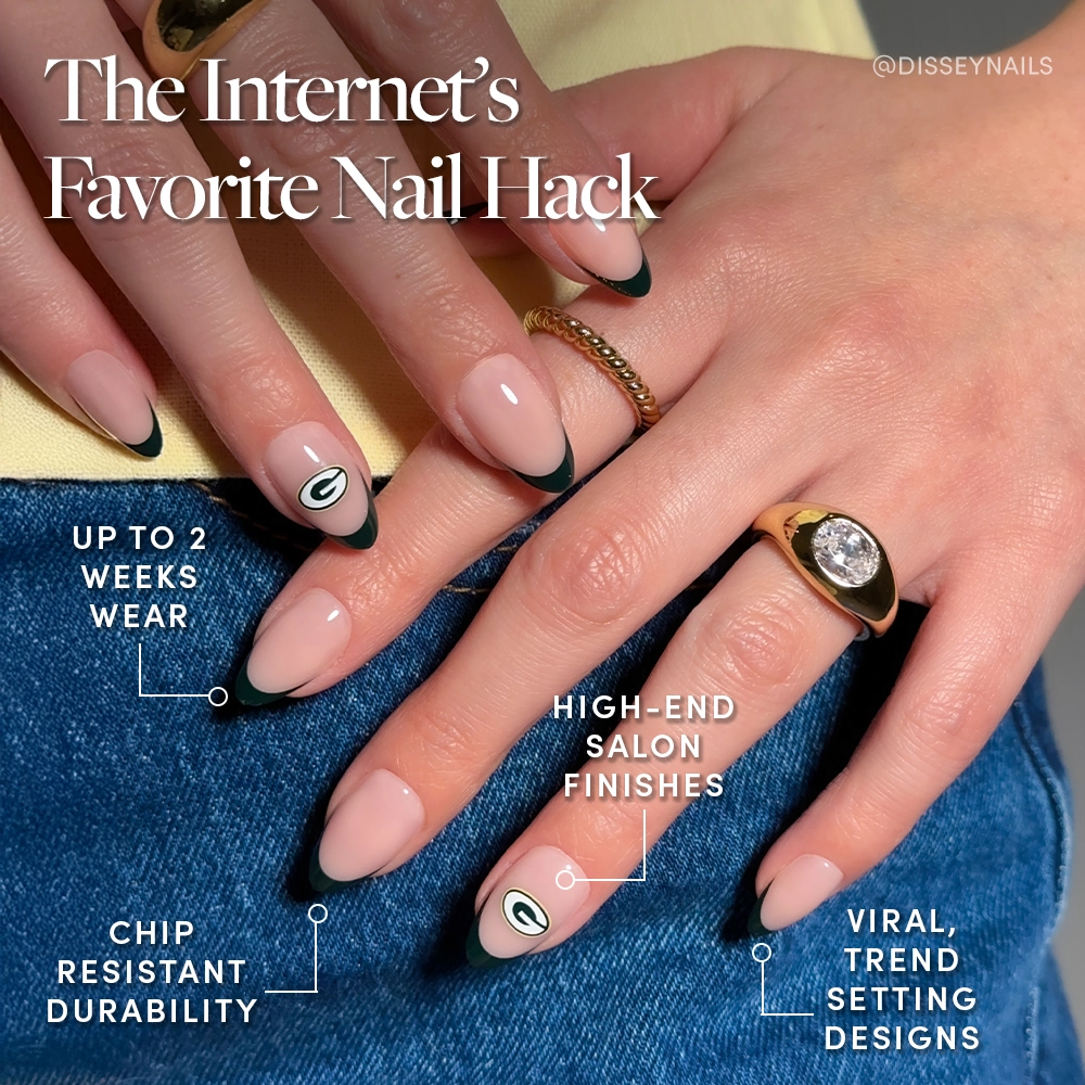 A close-up of hands with almond-shaped, nude nails featuring black French tips and a white-green accent inspired by the glamnetic Green Bay Packers Press-On Nail Set, highlighting its salon-quality finish, chip resistance, trendy style, and durability. - Product image