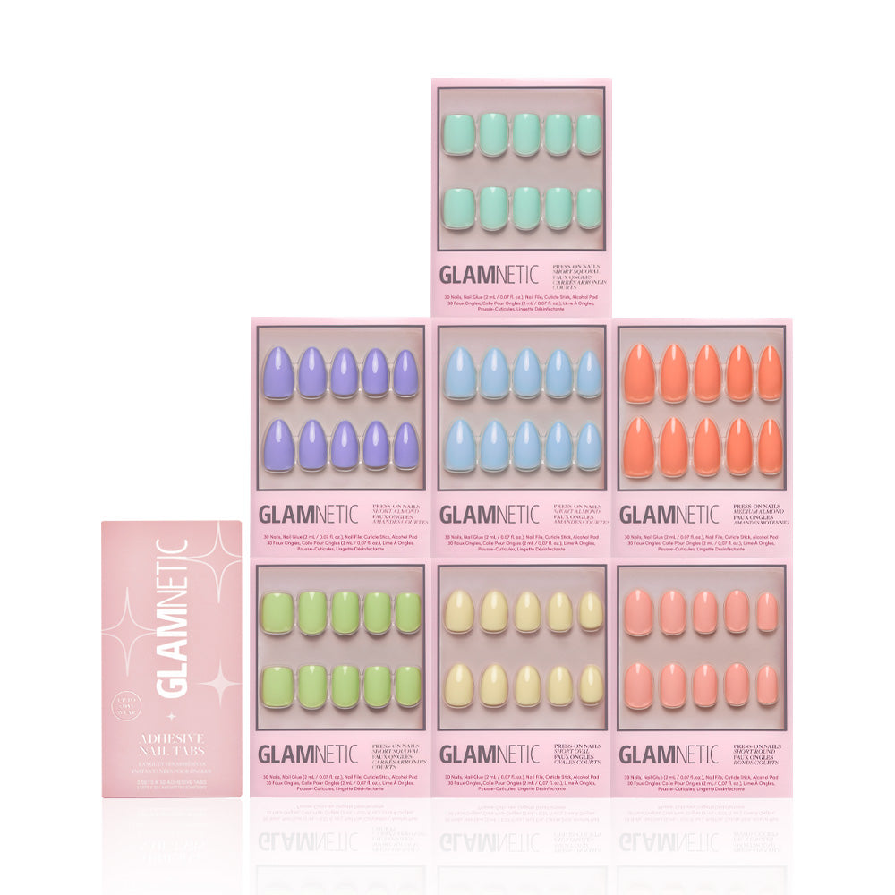 Eight boxes of glamnetic’s Hello Spring Collection press-on nails are stacked in a pyramid, each featuring glossy pastel solid shades such as mint green, purple, and peach. A pink glamnetic box is placed to the left. - Product image