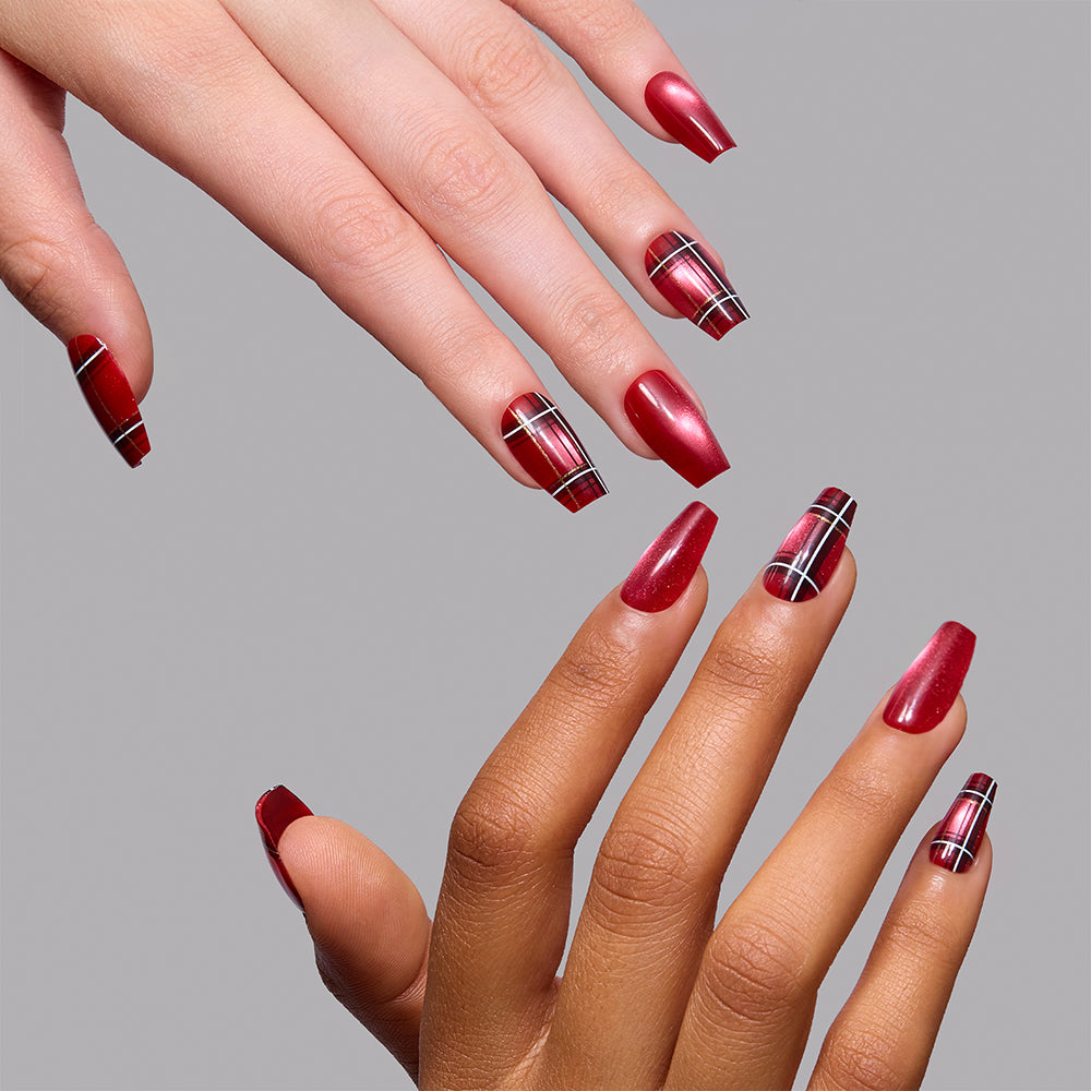 Three hands with long, squared red nails display a festive style. Some nails boast a black, white, and gold plaid pattern on a vibrant red base, evoking the Holiday Tartan press-on nails by glamnetic. The backdrop is plain gray. - Product image