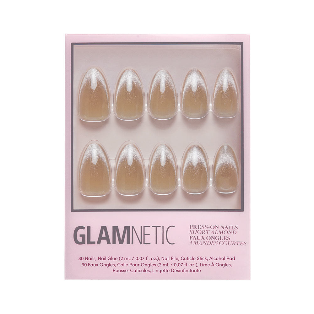 The glamnetic Honey Bun set includes short almond-shaped nude ombre press-on nails with a velvet finish, plus nail glue, file, cuticle stick, and alcohol pad. The pink box displays black and silver text. - Product image