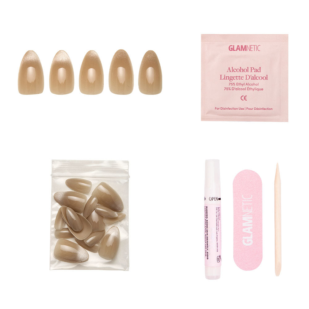 The glamnetic Honey Bun Nail Set includes nude, short almond-shaped velvet press-on nails, an alcohol pad, extra nails, nail glue, a pink nail file, and a wooden cuticle stick—all arranged on a white background. - Product image
