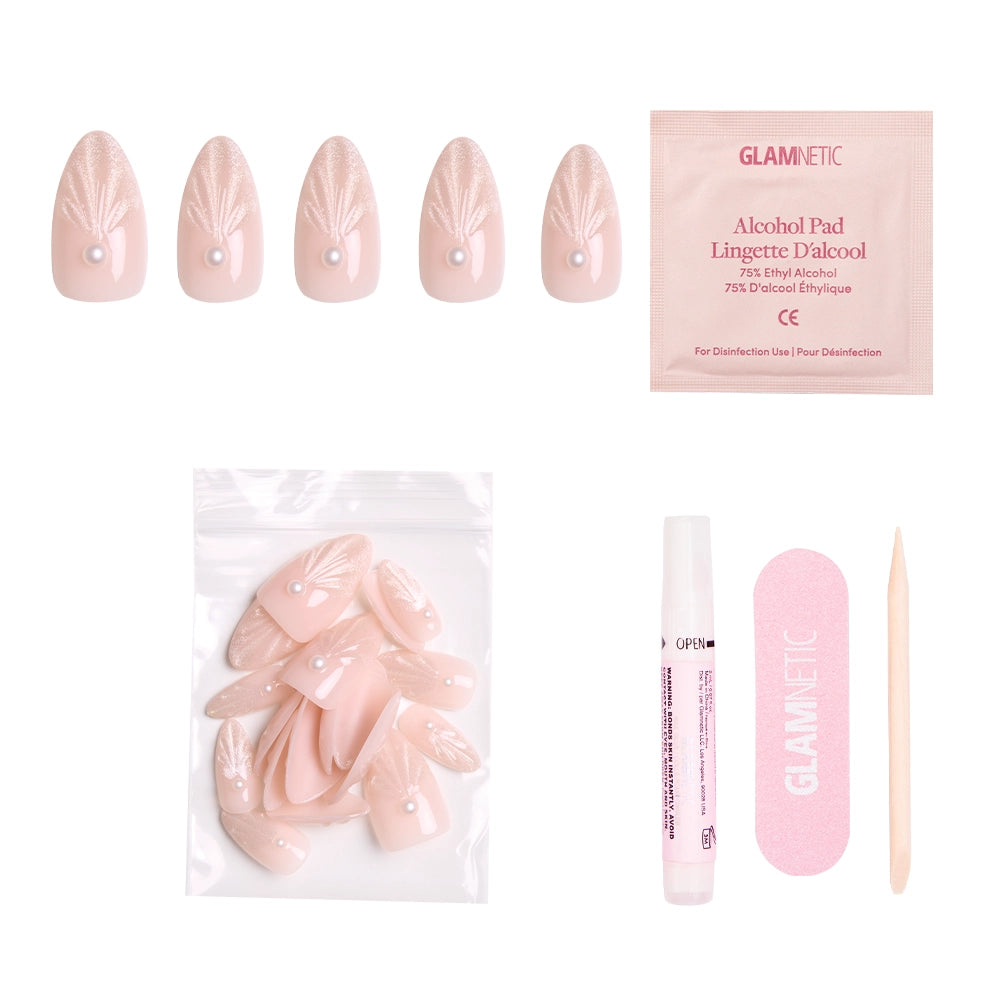 The glamnetic Honeymoon set includes pink press-on nails with white leaf designs, pearl accents, an alcohol pad, extra nails, nail glue, a pink file, and a cuticle stick—all displayed on a white background. - Product image