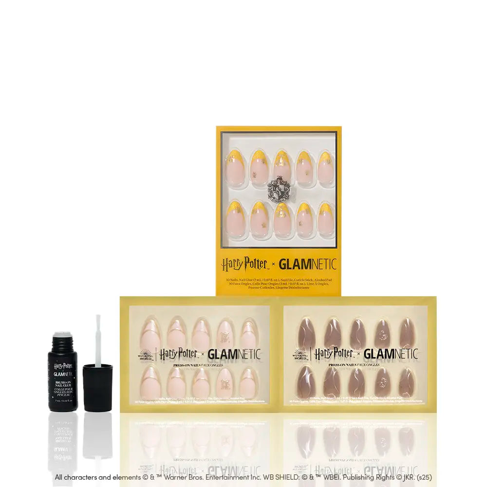 The glamnetic House Hufflepuff™ set includes three press-on nail kits in yellow and nude shades with golden designs, Hufflepuff-inspired nails, and one open adhesive bottle with a brush, all displayed on a white background. - Product image