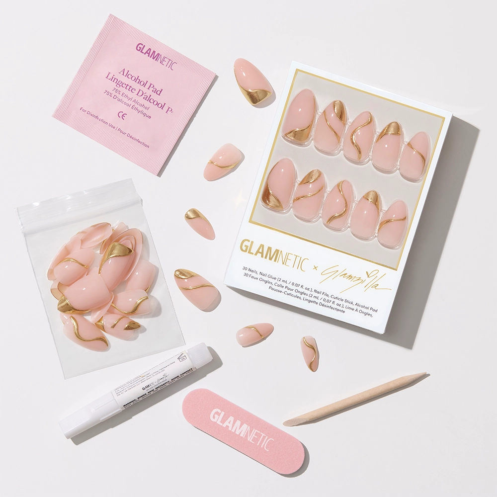 Flat-lay of the complete nail kit, including the boxed Glamnetic x Glamzilla nail set, extra loose nails in a zip pouch, a glue pen, an alcohol pad, a pink nail file, and a wooden cuticle stick—all laid out on a bright white background.
- Product image