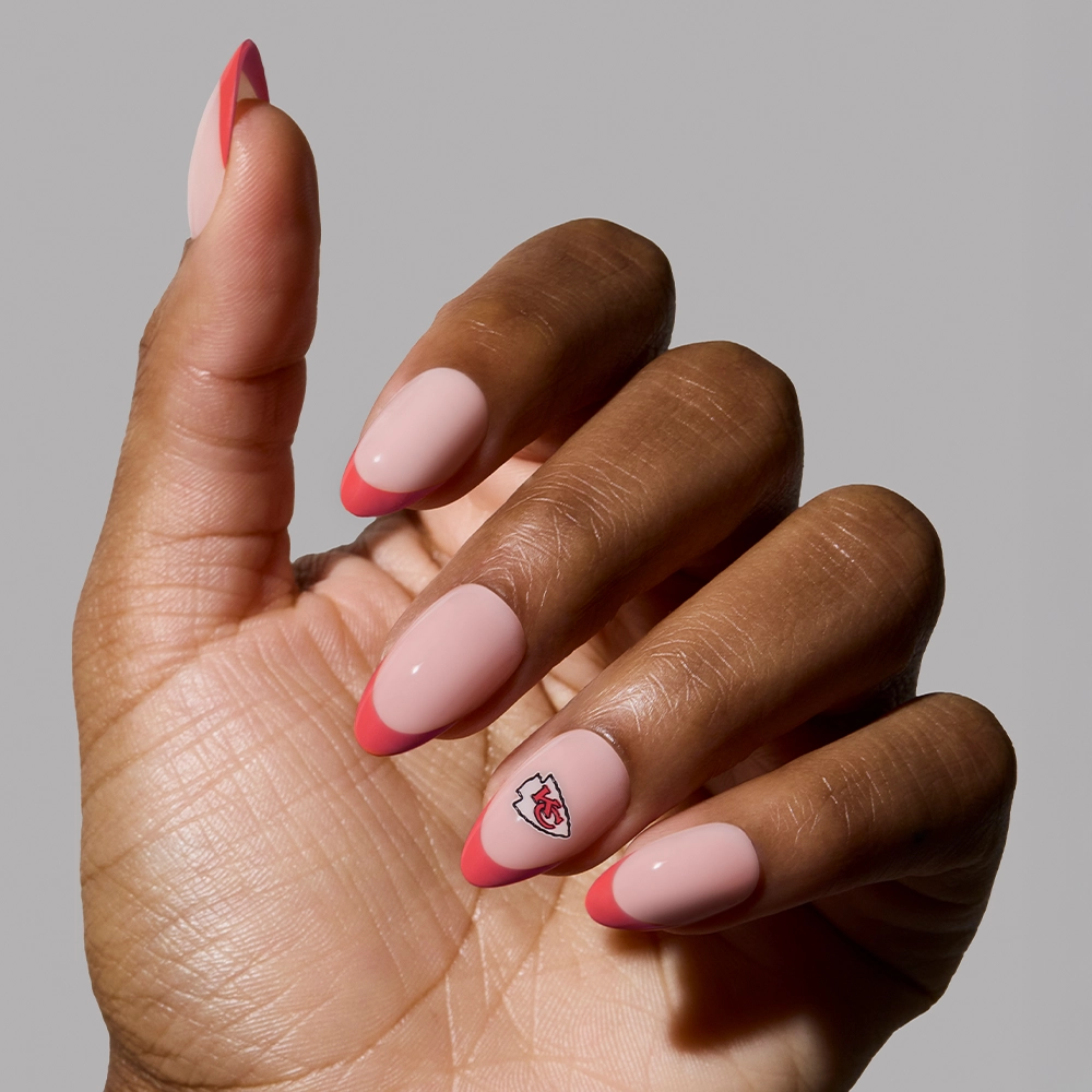 Show off stylish Chiefs pride with the glamnetic Kansas City Chiefs Press-On Nail Set—almond-shaped pink nails with red tips and a logo accent on the ring fingernail for standout team spirit. - Product image