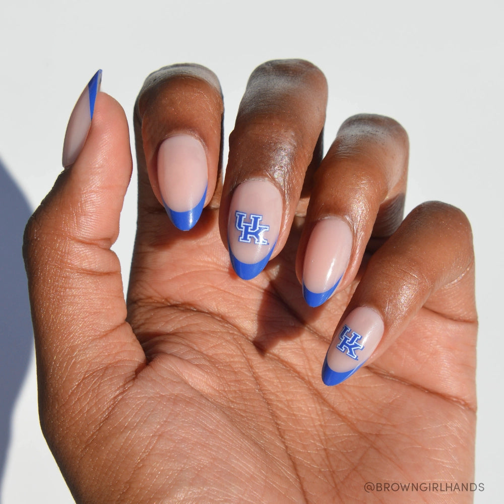 The Kentucky Wildcats Press-On Nail Set by glamnetic features almond-shaped, salon-quality nails with a nude base, royal blue French tips, and blue-and-white UK logos on two nails—all shown against a plain white background.