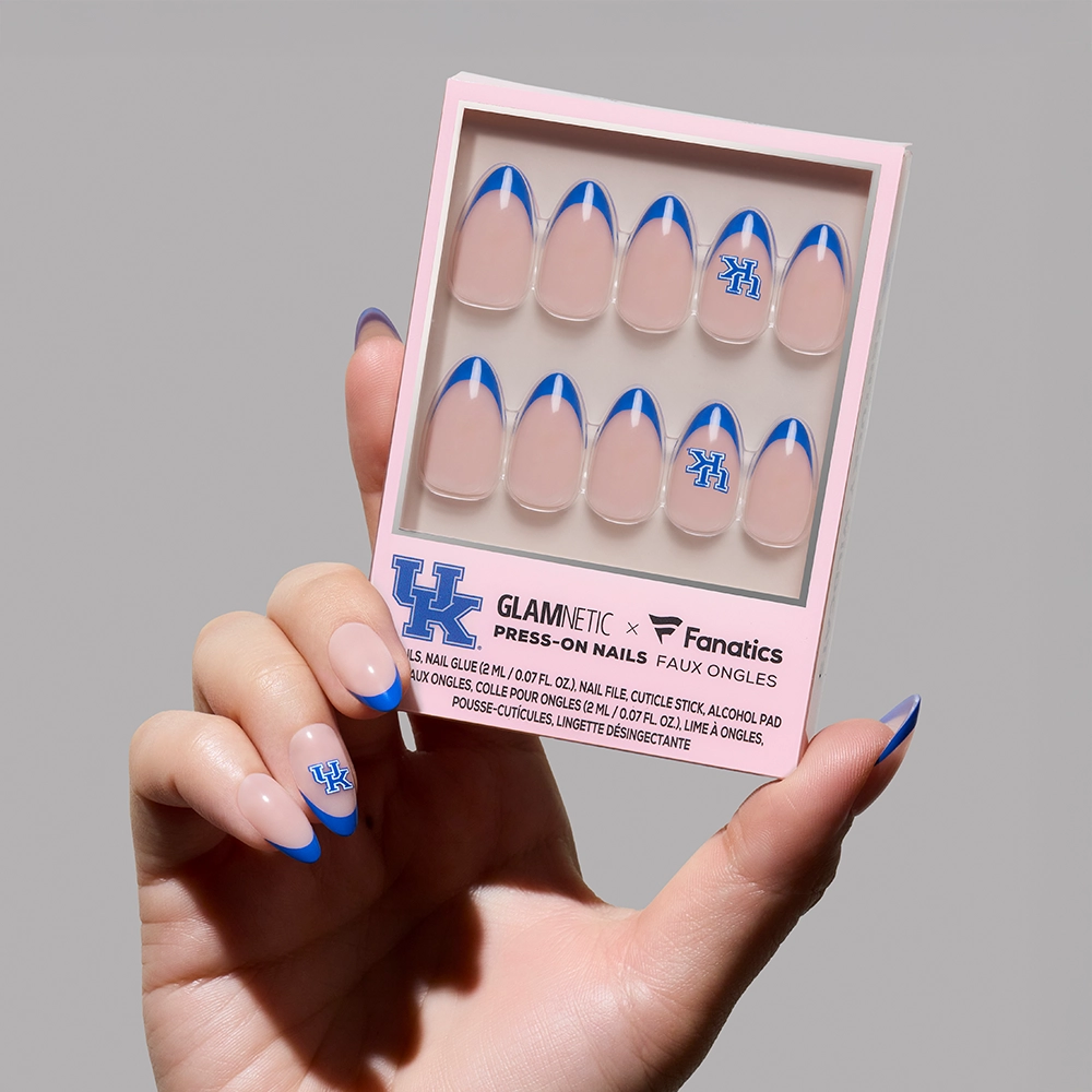 A hand with royal blue French tips holds a glamnetic Kentucky Wildcats Press-On Nail Set, featuring salon-quality nails with blue accents and the University of Kentucky UK logo on select nails.