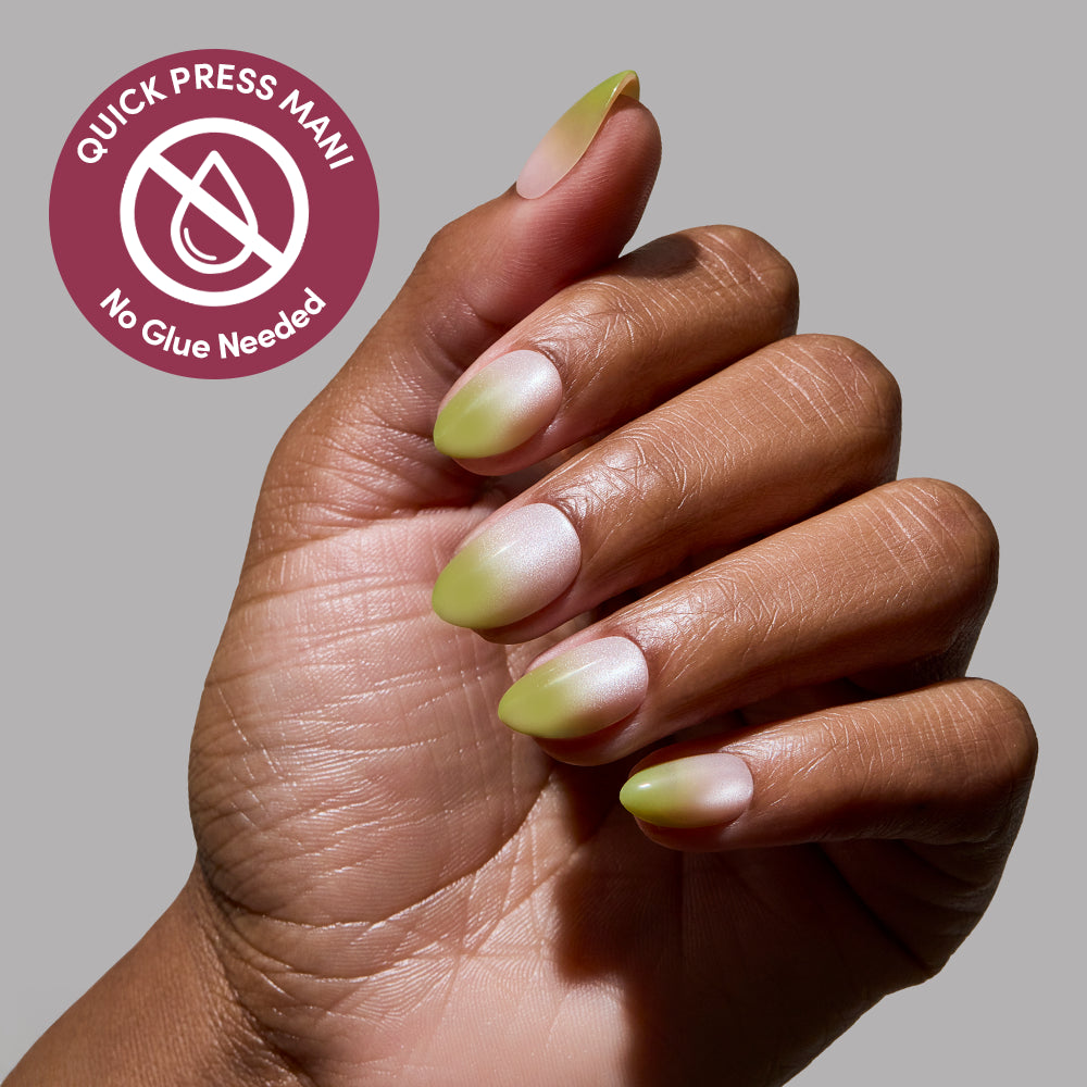 A hand with almond-shaped, gradient green glamnetic Lime Beam press-on nails is shown against a gray background. A circular badge reads “Quick Press Mani, No Glue Needed” with a crossed-out glue bottle—perfect nails in minutes. - Product image