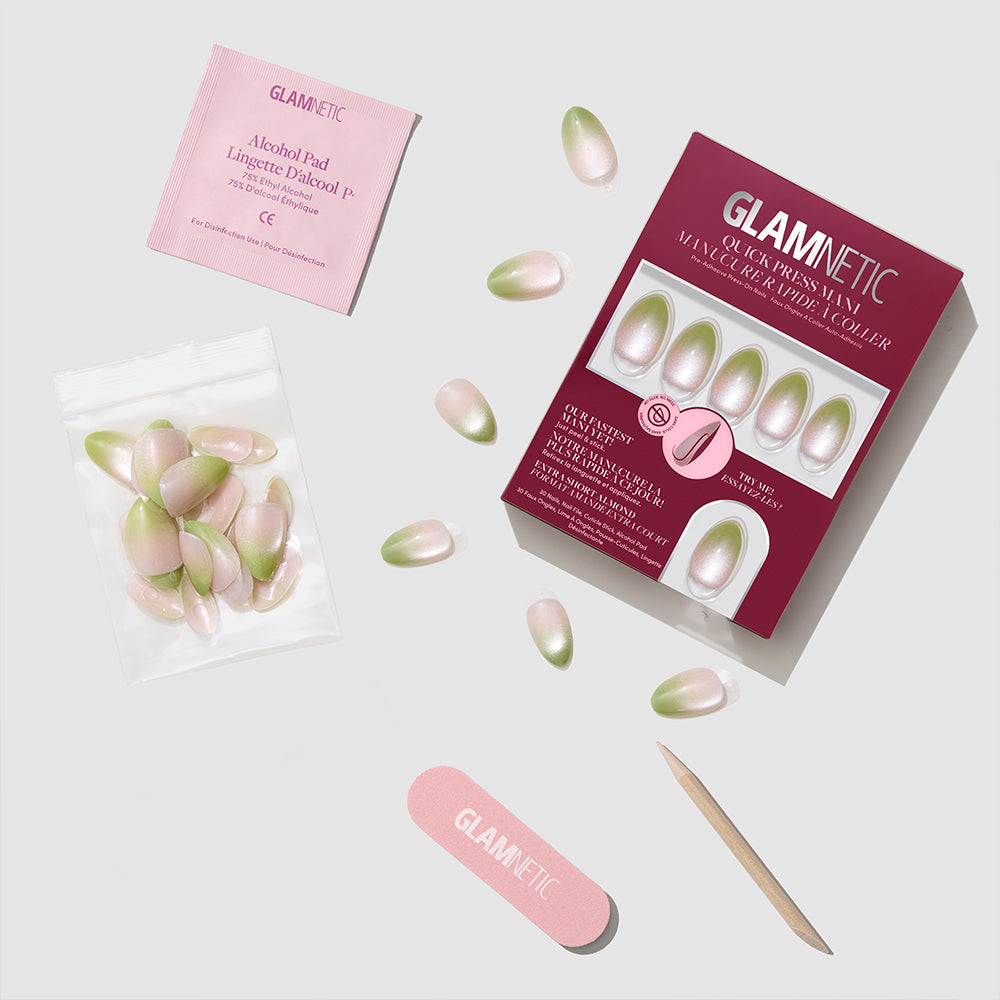 The glamnetic Lime Beam press-on nail kit includes pink and green ombre nails, a pink nail file, cuticle stick, nail glue, alcohol pad, and comes in a pink and maroon glamnetic box displayed on a light surface. - Product image