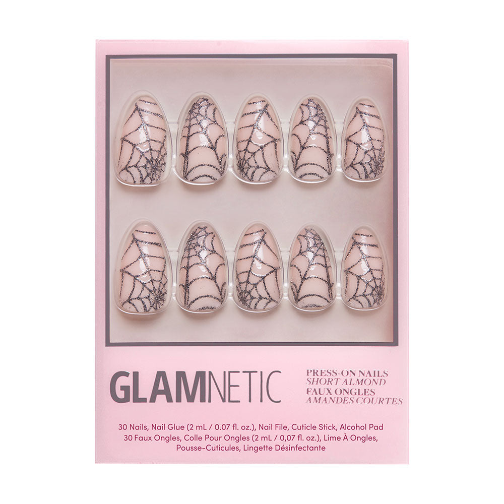 Glamnetic’s Lady Web press-on nail set features short almond nails with a clear base and black sparkly spiderweb design—ideal for Halloween. The pink box displays 10 nails arranged in two rows. - Product image