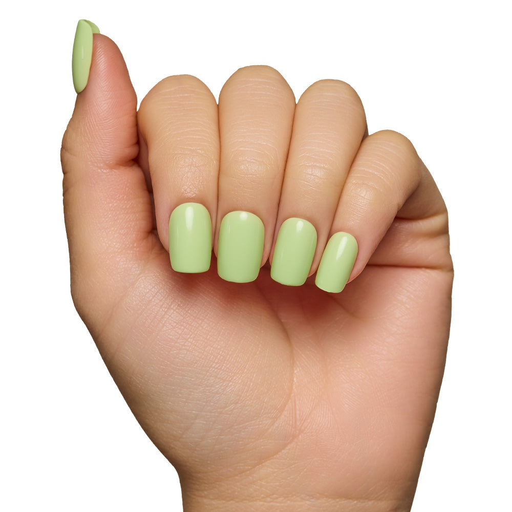A hand with short squoval nails, painted in glamnetics Light Sage, is displayed against a white background. The pastel green shade and glossy finish emphasize the neat manicure. - Product image