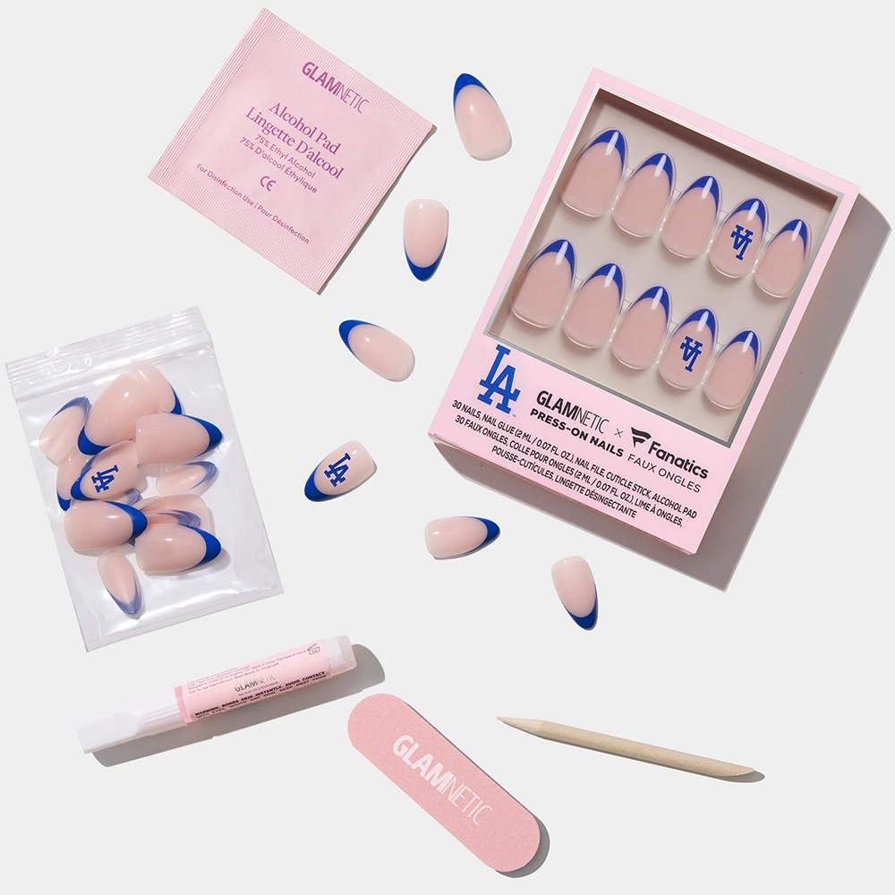 The glamnetic Los Angeles Dodgers Press-On Nail Set features blue-tipped nails with LA Dodgers logos, a pink nail file, wooden cuticle stick, glue, alcohol pad, and extra nails—all displayed on a white background. - Product image