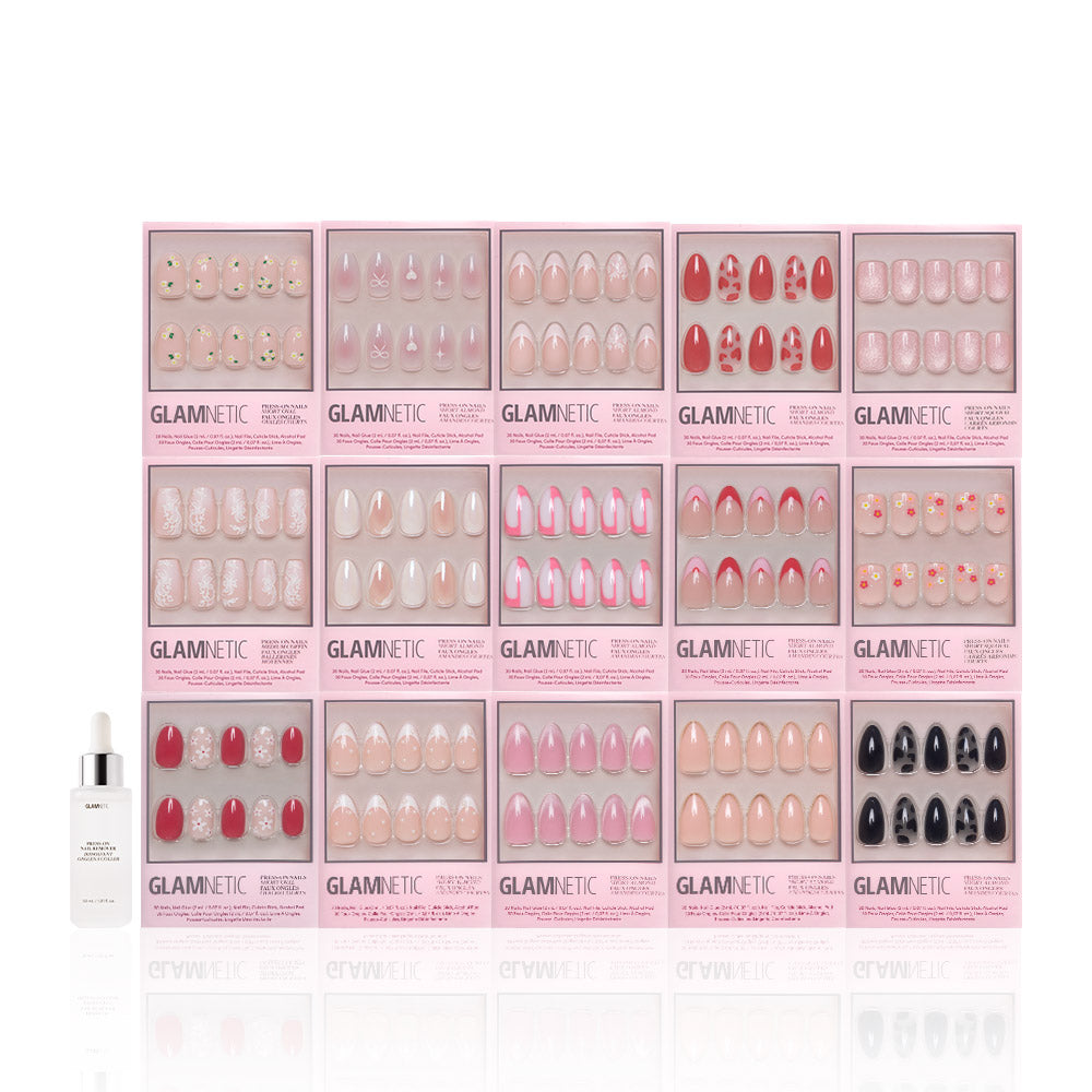 Sixteen boxes of glamnetic’s Love In Bloom Collection, featuring short almond and heart-accent press-on nails, are arranged in rows with a white nail glue bottle on the left, all set against a white background. - Product image
