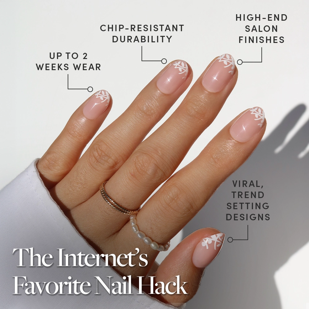 A hand with manicured nails wears glamnetic’s Love Preserved: nude polish with a delicate white leaf design. Enjoy up to 2 weeks wear, chip-resistant durability, salon-quality finish, and viral botanical nail art. - Product image