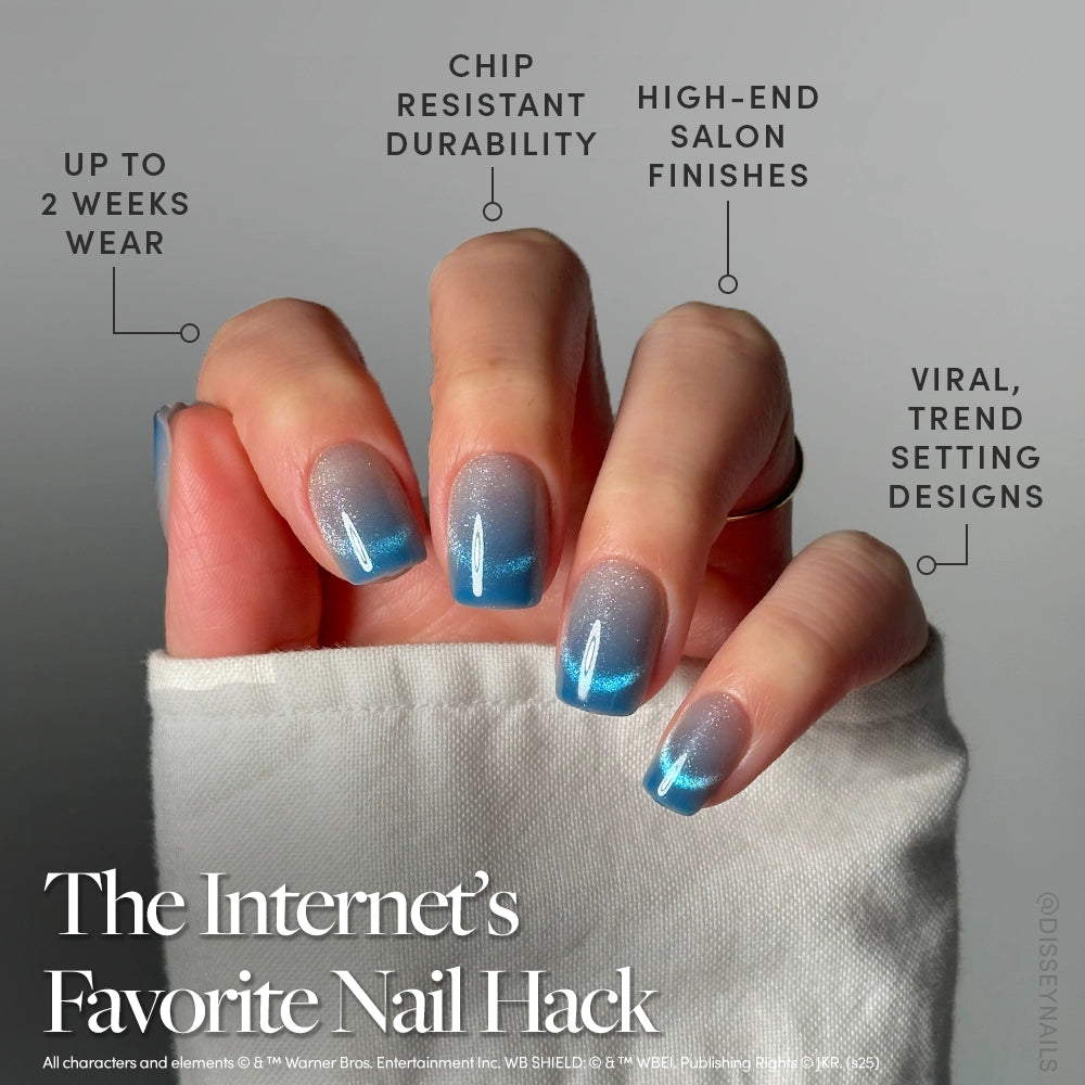 A hand in a white sleeve displays long, velvet blue gradient nails with glossy, salon-style finishes and white accent lines. Text highlights two-week wear, chip resistance, and trendy glamnetic Lumos Nail Set designs. - Product image