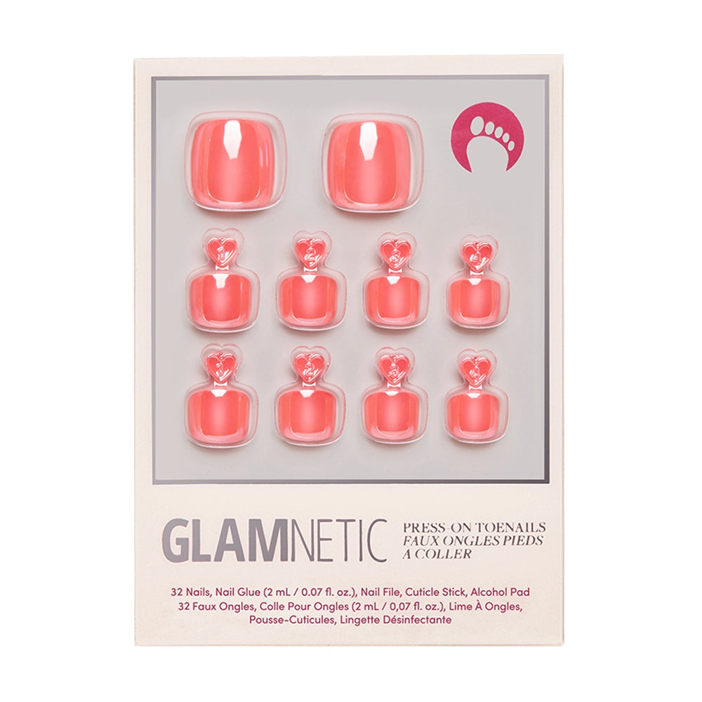 The Lush Coral Toenail set by glamnetic features 12 vegan, coral-colored, glazed finish press-on toenails plus glue, cuticle stick, nail file, and alcohol pad—packaged in a clear plastic tray.