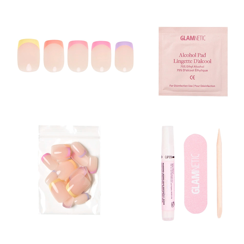 The glamnetic Macarons kit includes pastel French tip press-on nails, an alcohol pad, extra nails, glue, a pink nail file, and a wooden cuticle stick—beautifully arranged on a white background. - Product image