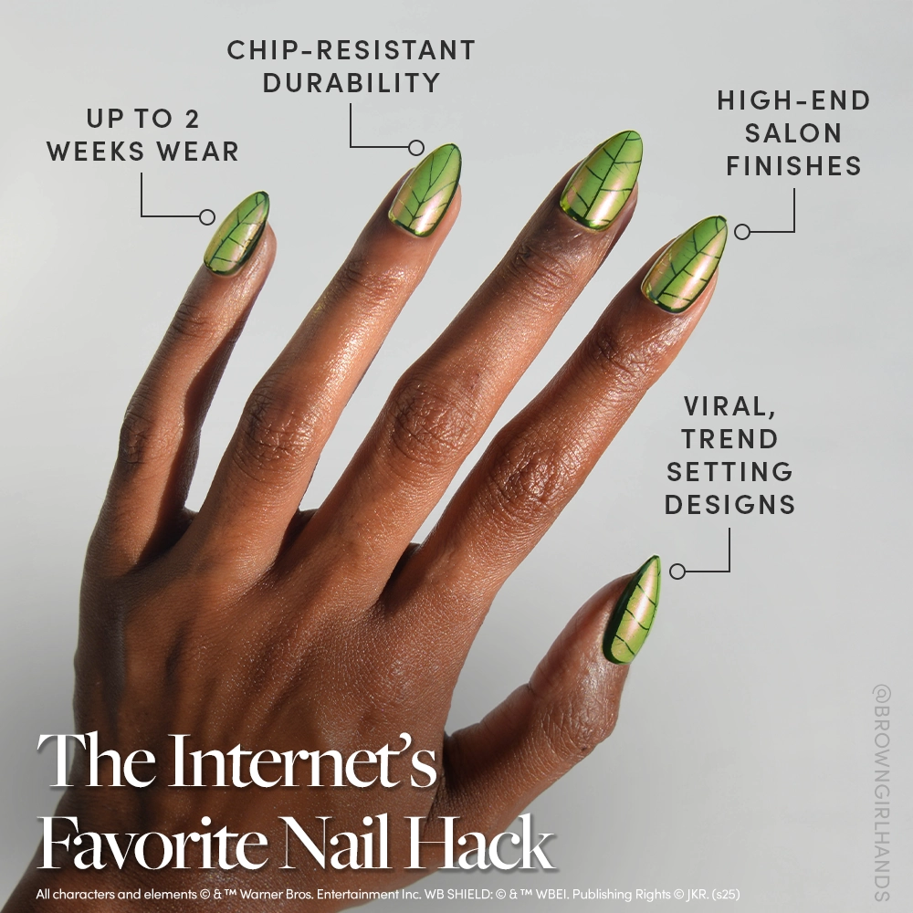 A hand with dark brown skin displays glossy green almond nails with black leaf designs, inspired by magical plants. The glamnetic Mandrake Nail Set is chip-resistant, long-lasting, trendy, and offers salon-like quality. Limited edition. - Product image