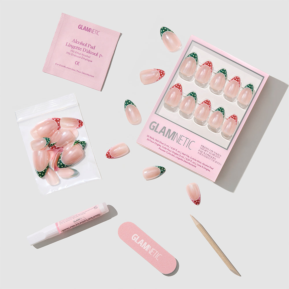 Matching PJs short almond press-on nails featuring red and green strawberry patterns, including a storage box, loose nails, nail glue, an alcohol pad, a nail file, and a cuticle stick. - Product image