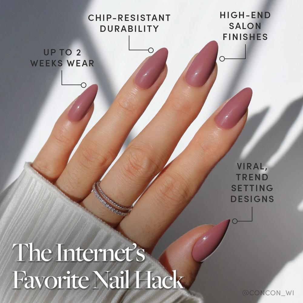 A hand wears glamnetic’s Mauve Wife almond-shaped press-on nails—long, glossy mauve with viral designs. Text highlights chip-resistant durability, salon-quality finish, up to 2 weeks’ wear. The look is accessorized with silver rings. - Product image