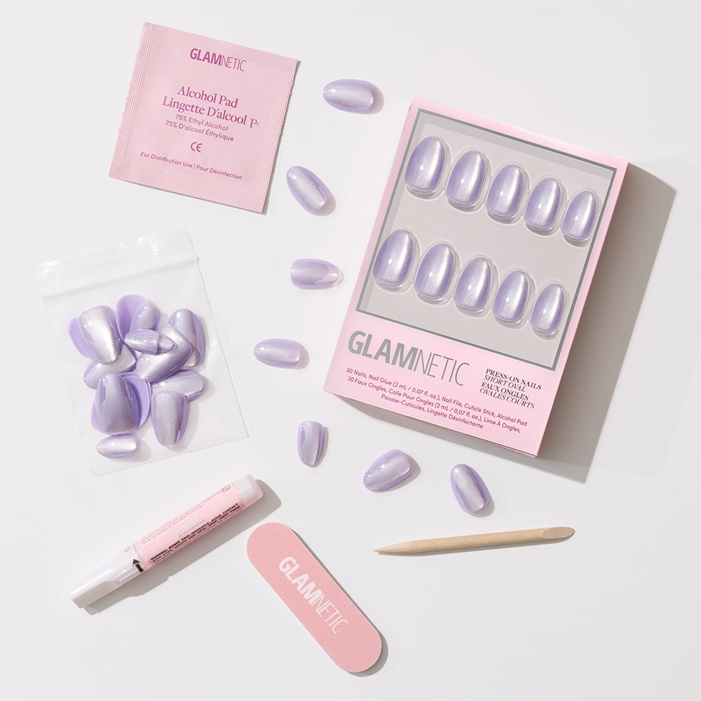 A set of glamnetic Mermaids Tail iridescent purple press-on nails with a glossy finish, shown with an applicator tube, nail file, wooden cuticle stick, alcohol pad, and extra nails on a white background. - Product image