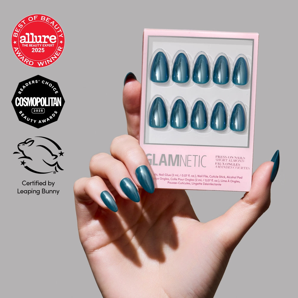 A hand with salon-quality glamnetic Midnight Teal press-on nails holds a box. Beauty award badges from Allure and Cosmopolitan, plus the Leaping Bunny certification logos, are displayed on the left side of the image.