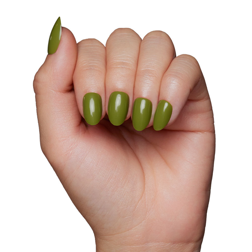 A hand with light skin tone shows off glossy Moss Green nails by glamnetic—a perfect fall shade—against a white background. - Product image
