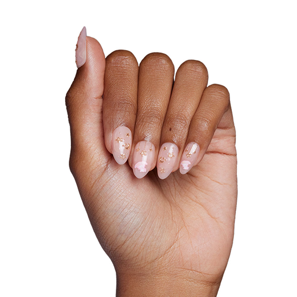 A neatly manicured hand with long, almond-shaped glamnetic My Melody™ nails features a sheer pink base and whimsical gold stars and clouds against a white background. - Product image