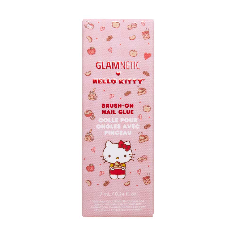 A pink box of glamnetic Hello Kitty™ Brush-On Nail Glue, 7 mL (0.24 fl. oz.), features apple, bow, and heart designs plus English and French text—perfect for at-home manicures. - Product image