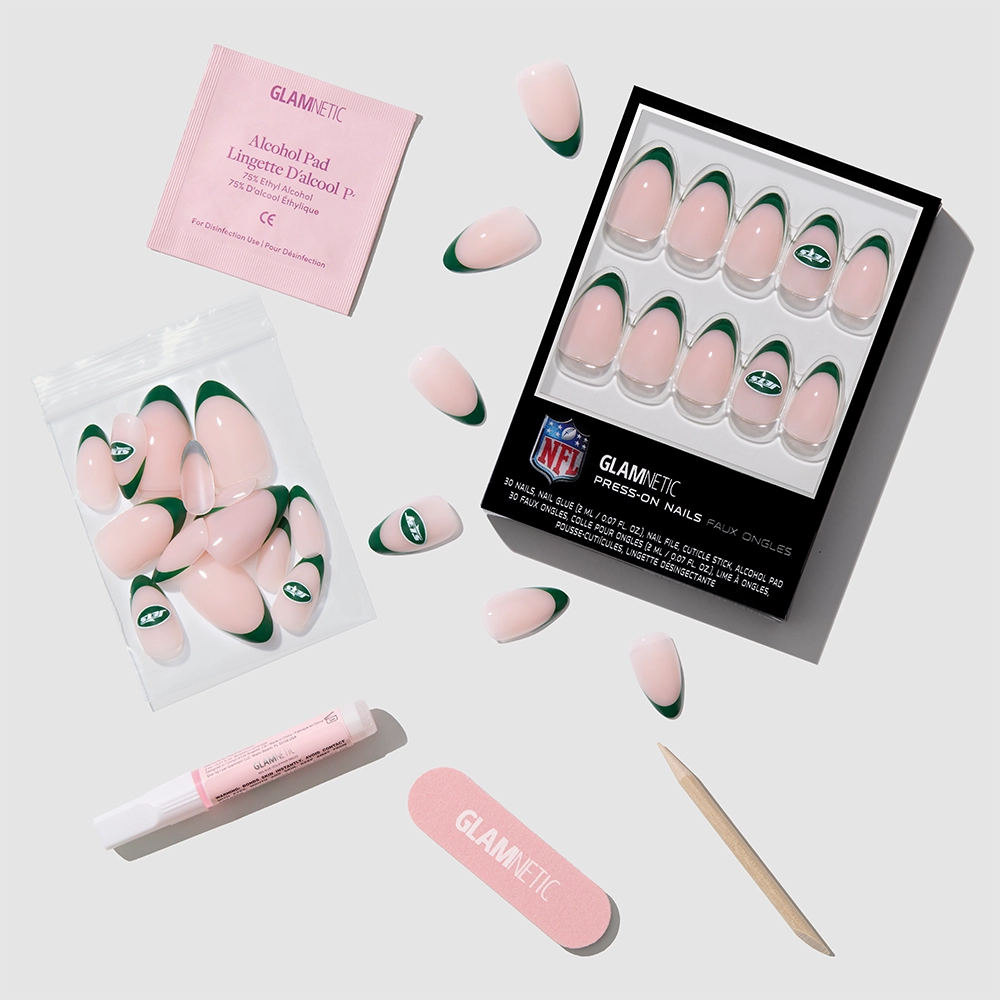 The glamnetic New York Jets Press-On Nail Set features green and pink almond French tip nails with the Jets logo, plus an alcohol pad, glue, nail file, cuticle stick, and extra nails—all arranged on a light background. - Product image