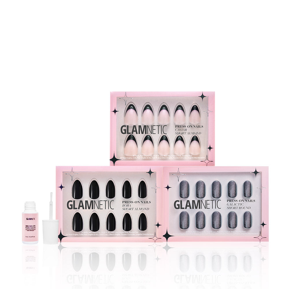 Three boxes of glamnetic press-on nails in the Noir Classics style are stacked. To the left is an open bottle of glamnetic Brush On Glue with its applicator. The background is white. - Product image