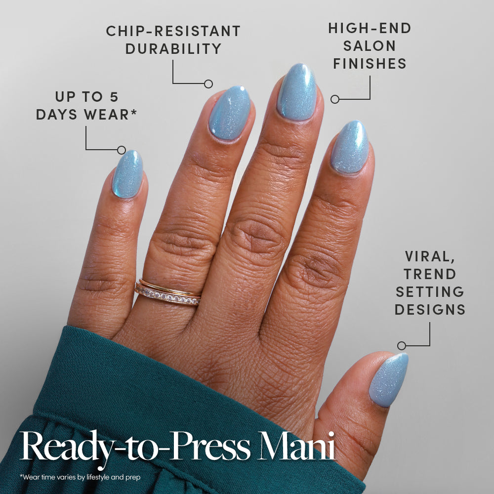 A hand with glamnetic Ocean Prism sparkling blue stick-on nails is shown. Text highlights up to 5 days wear, chip-resistant durability, salon-quality finish, and trendy designs. The person wears gold rings and a teal sleeve. - Product image