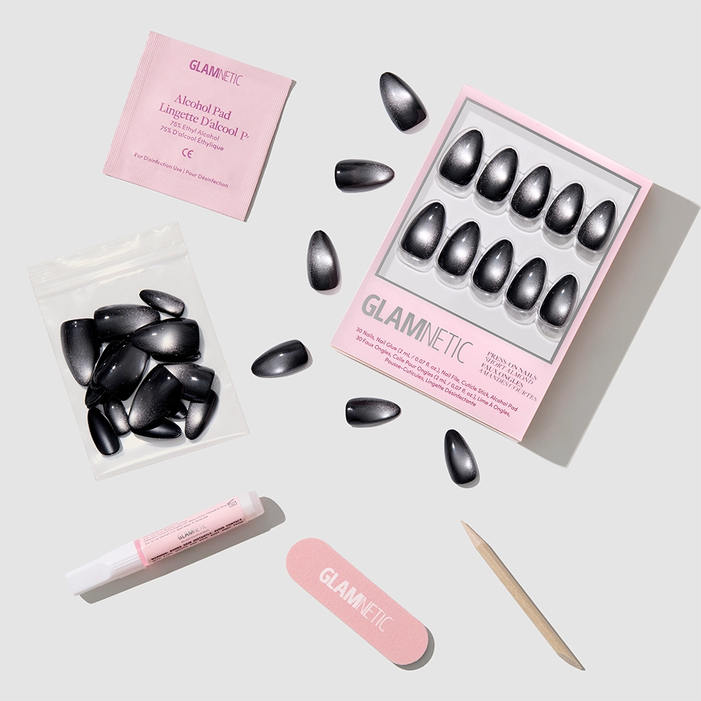 Obsidian by glamnetic: short almond press-on nails with extra nails, a pink nail file, wooden cuticle stick, nail glue, and alcohol pad. Both the salon-quality packaging and nail file feature the glamnetic logo. - Product image